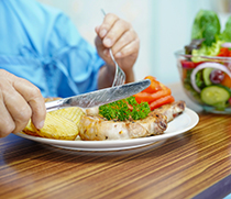 Teller mit Mittagessen und Salatschüssel